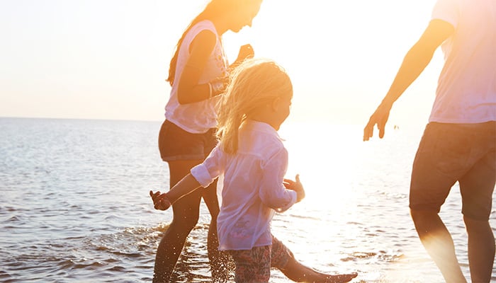 Familie pootjebadend in zee