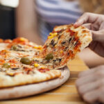 Persoon pakt pizza punt