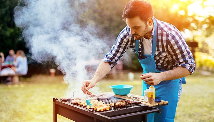 Man braad vlees op barbecue