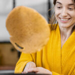 Vrouw flipt pannenkoek