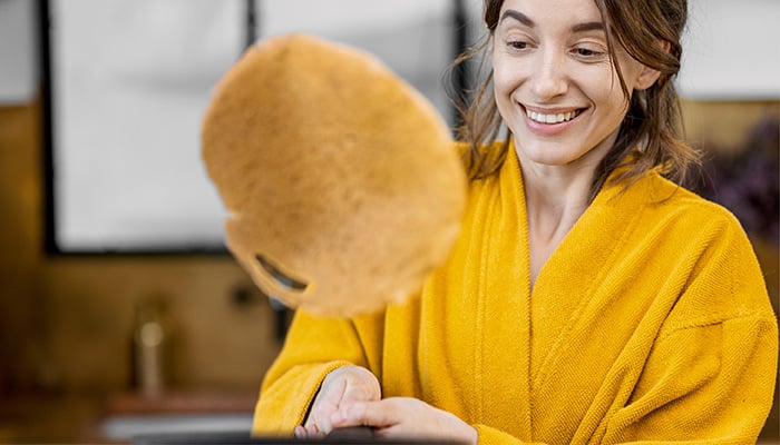 Vrouw flipt pannenkoek