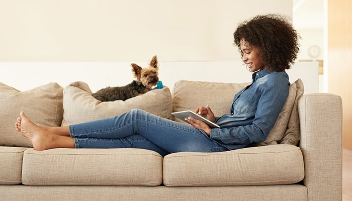 Vrouw met tablet op bank