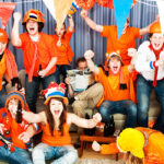 Feestende mensen in oranje outfits
