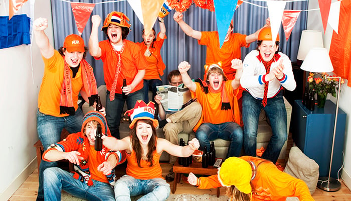 Feestende mensen in oranje outfits