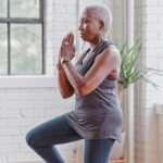 Vrouw staat in yogapose