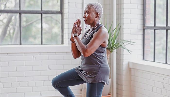 Vrouw staat in yogapose