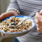 Vrouw eet uit een bord granola