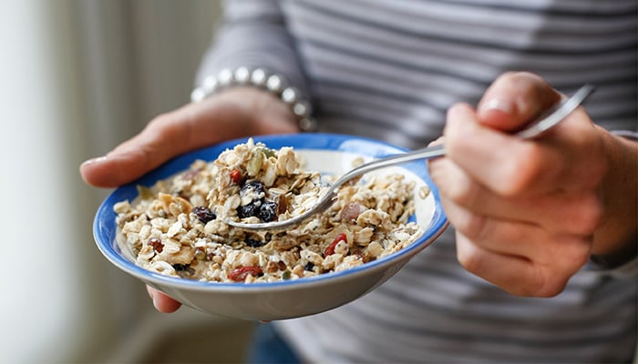 Vrouw eet uit een bord granola