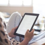 Vrouw zit op de bank met tablet
