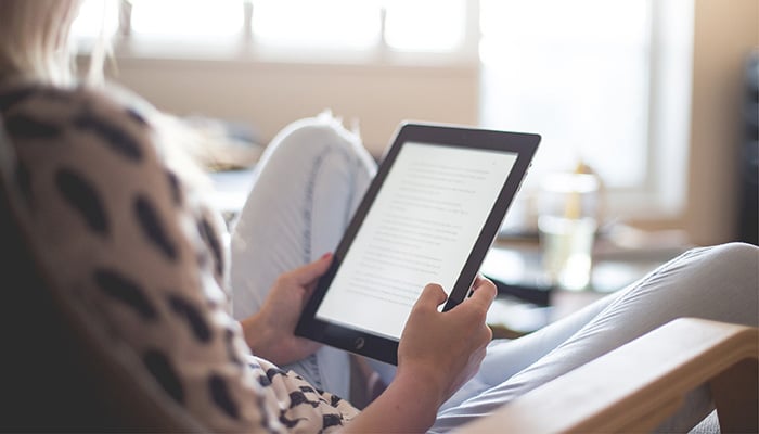 Vrouw zit op de bank met tablet