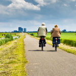 Twee mensen fietsen in de polder