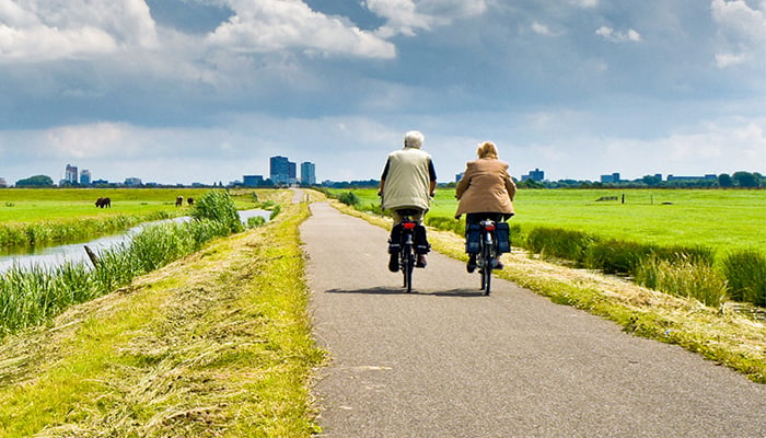 Twee mensen fietsen in de polder