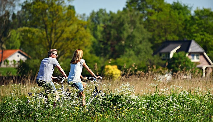 Man en vrouw fietsen door een natuurgebied