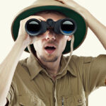 Man in safari outfit met verrekijker