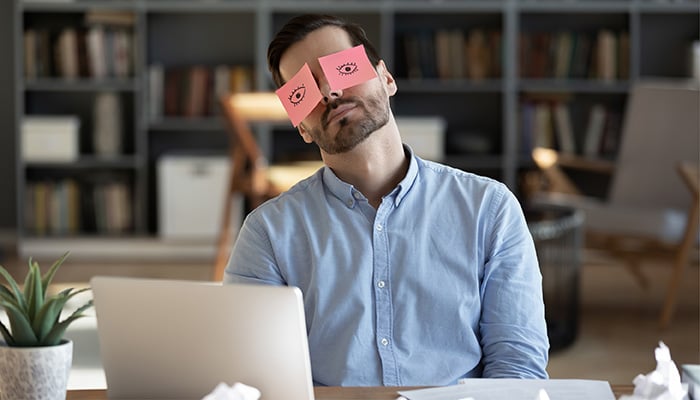 Man slaapt achter zijn laptop