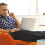 Man werkt op computer in fauteuil
