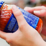 Hand met pot saus