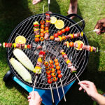 Bovenaanzicht van barbecue met groentespiezen erop