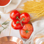 Tafel met pasta, tomaten en verse kruiden