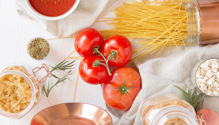 Tafel met pasta, tomaten en verse kruiden