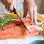 Zalm wordt gesneden op snijplank