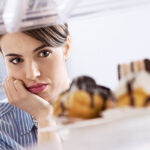 Vrouw kijkt verlangend naar gebakjes