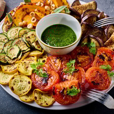 Bord met geroosterde groenten en salsa verde