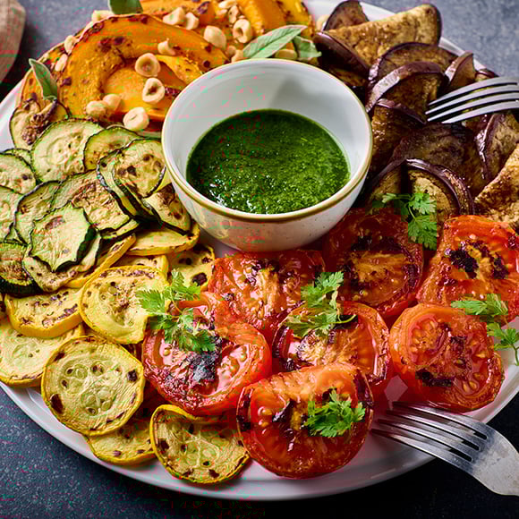 Bord met geroosterde groenten en salsa verde