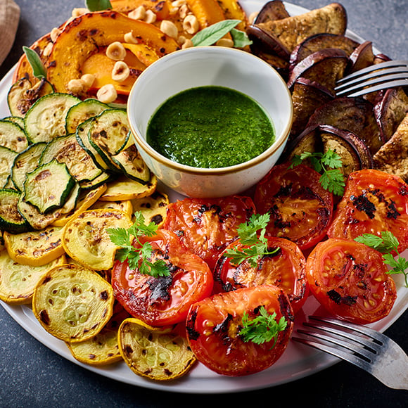 Bord met geroosterde groenten en salsa verde