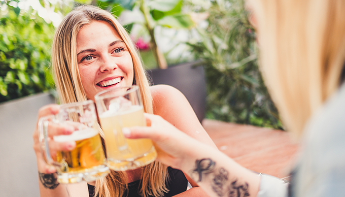 Meisje lacht en proost met bierglas