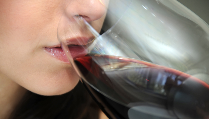 Close-up van vrouw die wijn drinkt uit wijnglas