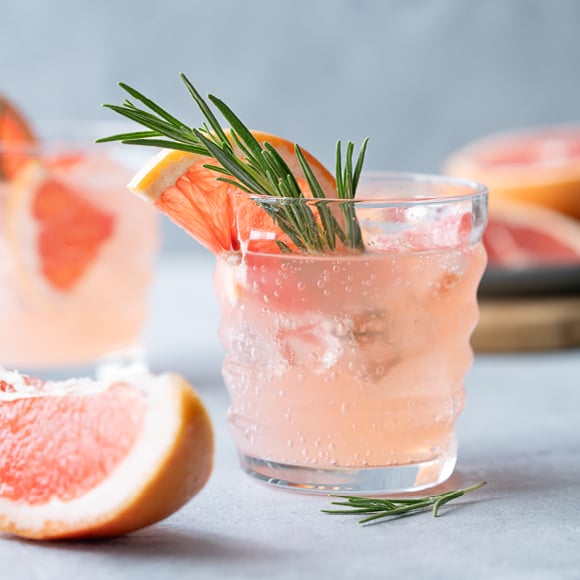 Glas met een grapefruit-tonic drankje en een takje rozemarijn