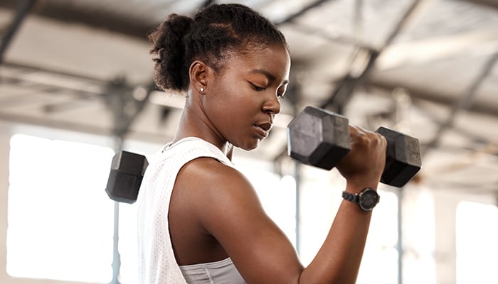 Dame traint haar linkerbicep met dumbbell
