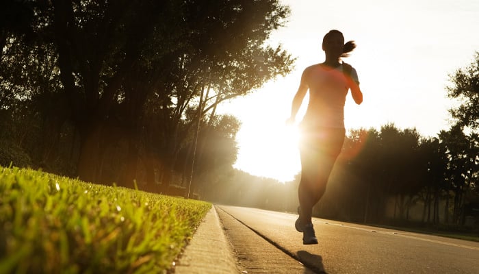 Vrouw loopt hard in de vroege ochtend