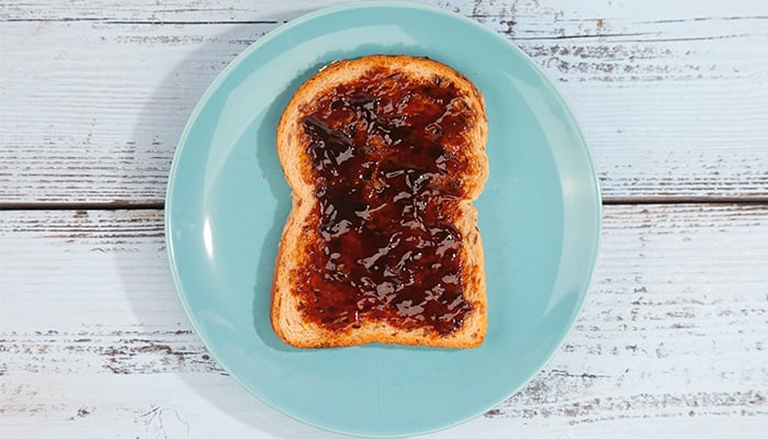 Bord met boterham gesmeerd met appelstroop