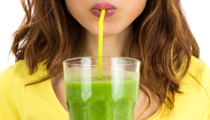 Close-up van vrouw die een smoothie met een rietje drinkt